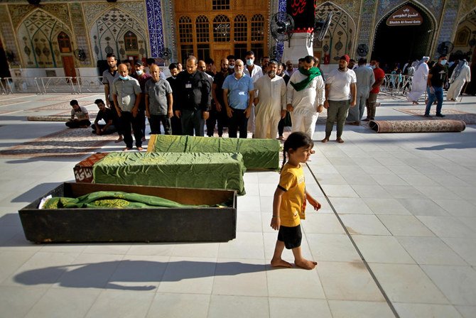 Des personnes en deuil prient dans une mosquée avant d’enterrer les victimes d’un attentat à la bombe commis lundi dans un marché bondé de Bagdad, à la veille de la fête musulmane de l’Aïd al-Adha. (AP)