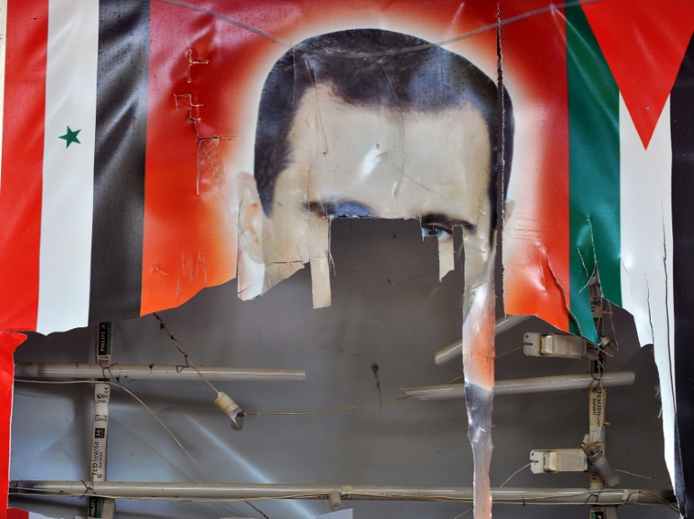 Portrait déchiré du président syrien Bachar al-Assad, dont le régime est accusé de nombreux crimes contre l'humanité, dont des attaques à l'arme chimique, dans une localité syrienne proche de la Turquie, le 10 novembre 2012. (AFP - Bulent KILIC)