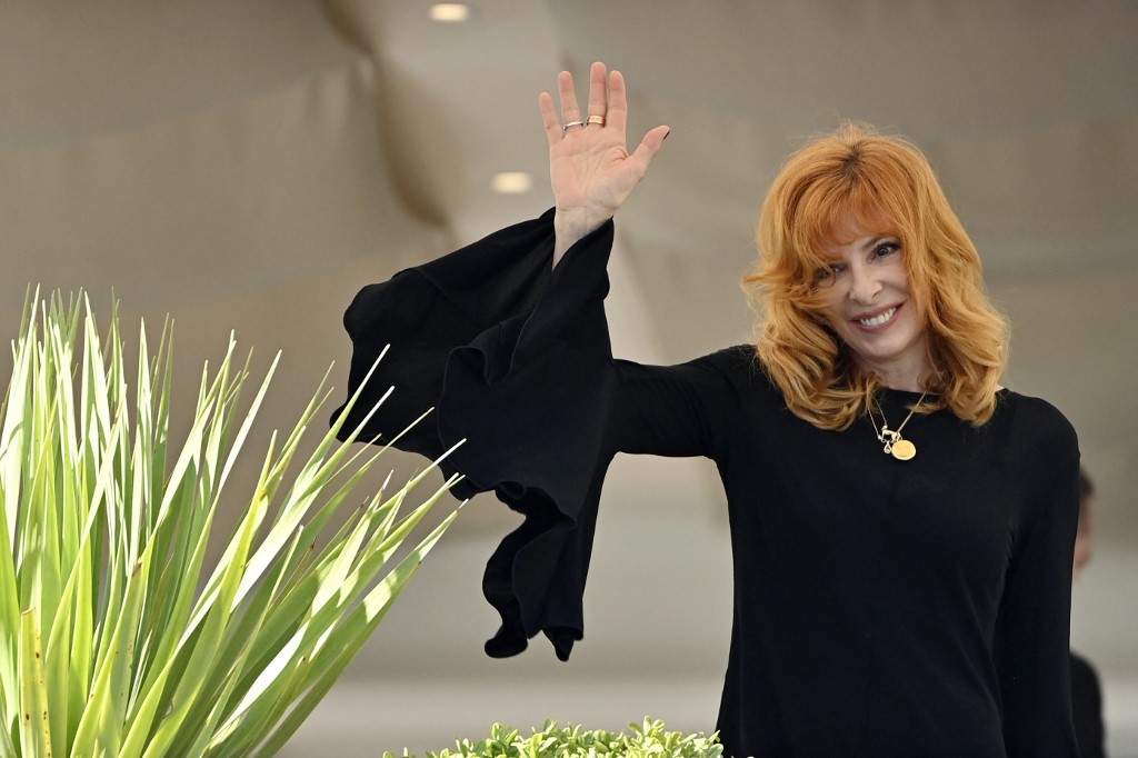 La chanteuse franco-canadienne et membre du Jury de la Sélection Officielle Mylène Farmer salue depuis le balcon de l'hôtel Martinez à la veille de l'ouverture de la 74e édition du Festival de Cannes (AFP)