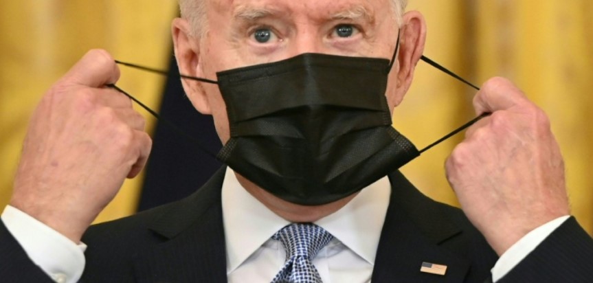 Le président américain Joe Biden enlève son masque avant un discours à la Maison Blanche, le 29 juillet 2021 - AFP