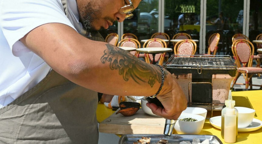 Le chef afro-américain Jerome Grant prépare un plat dans son restaurant "Jackie", à Washington, le 25 juin 2021. Photo Eva HAMBACH AFP