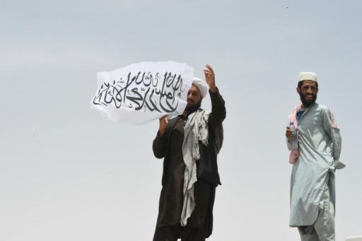 Un homme tient le drapeau taliban au côté afghan du point de passage de Chaman, le 17 juillet 2021 à la frontière avec le Pakistan. Archives AFP