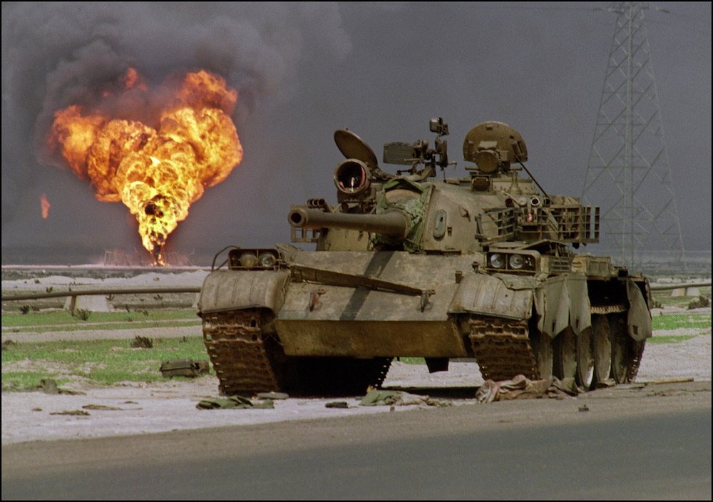 Un char T-62 irakien fabriqué par les Soviétiques a été abandonné dans le désert du Koweït le 2 avril 1991, au moment où un puits de pétrole du champ pétrolifère d'Al-Ahmadi brûle à l'arrière-plan. (AFP/File Photo)