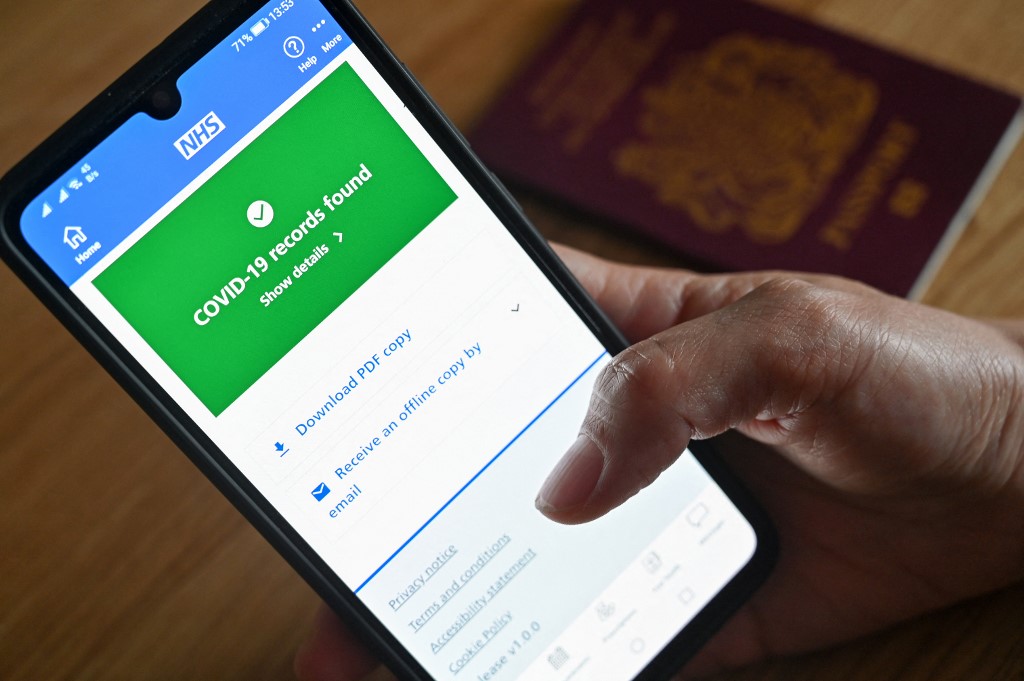 Une image d'illustration montre un écran de smartphone affichant un enregistrement de vaccin Covid-19 sur l'application National Health Service (NHS) à Londres (photo d'archives) (AFP)