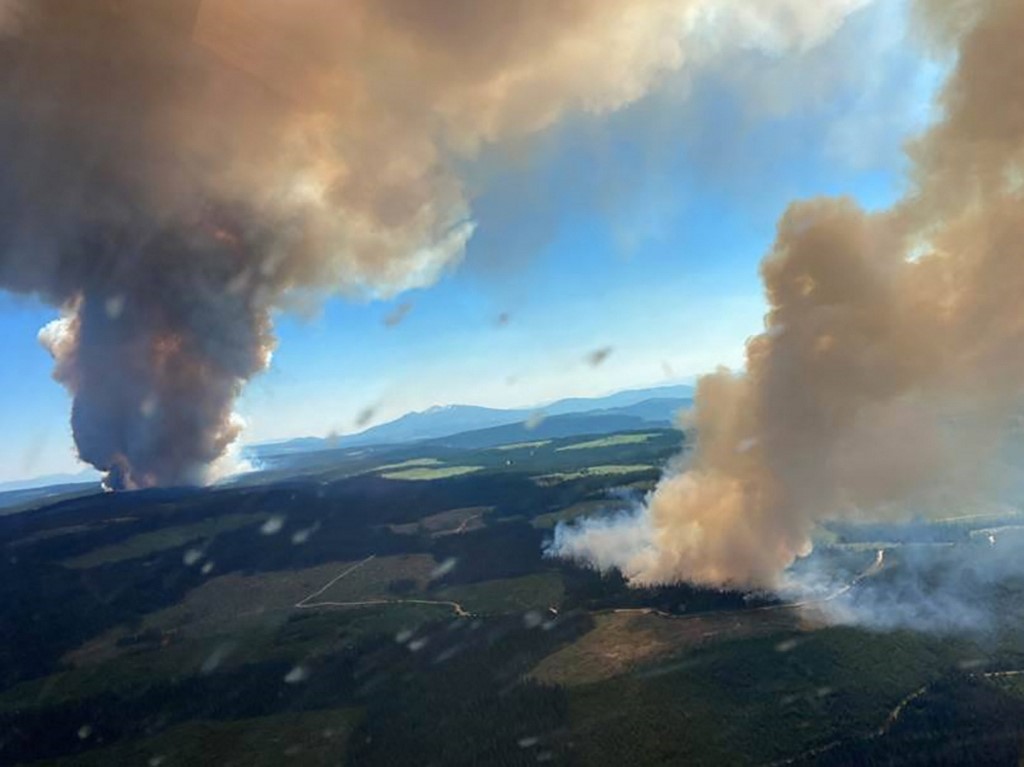 Cette photo de document reproduite avec l'aimable autorisation du BC Wildfire Service montre deux panaches de fumée provenant de l'incendie de forêt de Long Loch et de Derrickson Lake, en Colombie-Britannique (AFP)