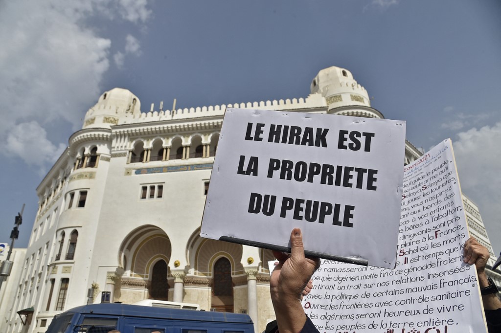 Des Algériens portent des pancartes lors d'une manifestation antigouvernementale dans la capitale Alger La pancarte indique en français : «Le Hirak appartient au peuple» (photo d'archives )(AFP)