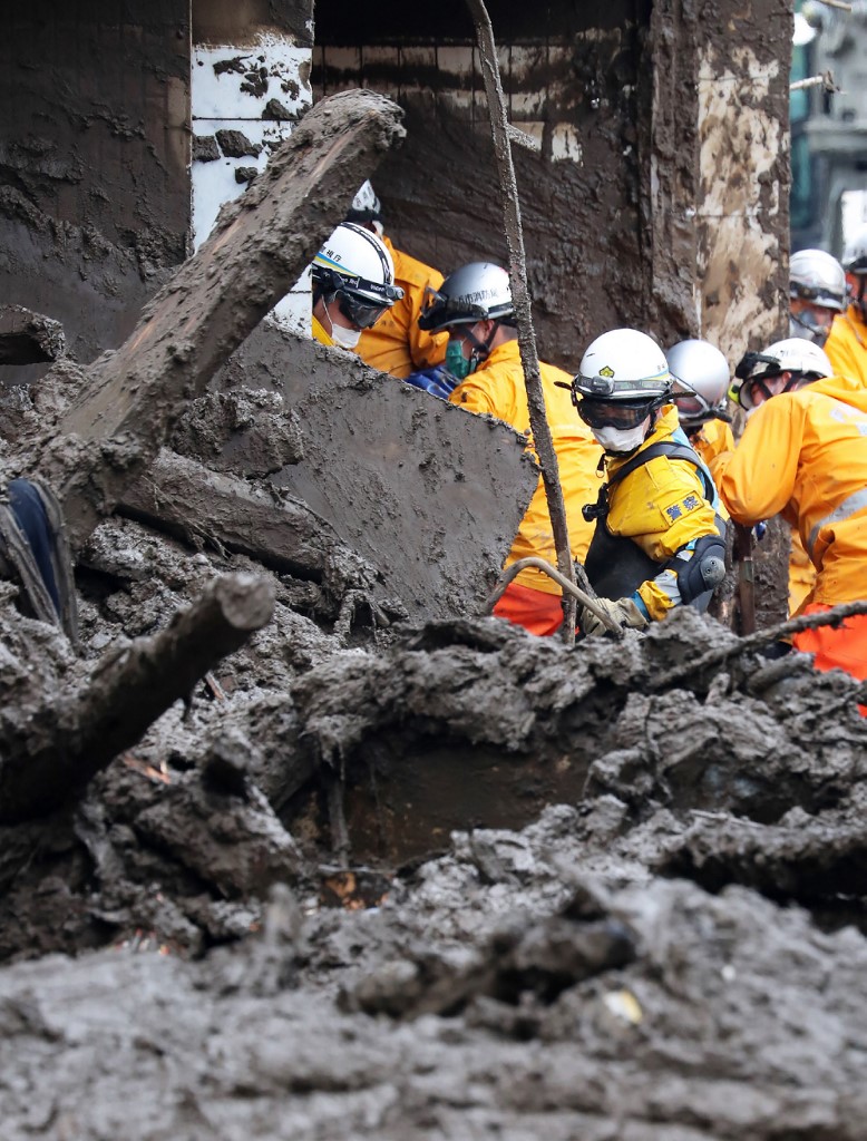 Des policiers recherchent des personnes disparues sur les lieux d'un glissement de terrain après des jours de fortes pluies dans la région d'Izusan à Atami (AFP)