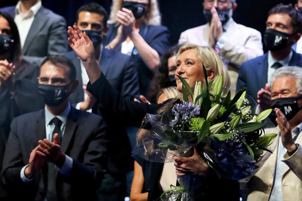 Marine Le Pen, chef du parti politique français d'extrême droite le Rassemblement national (RN) et députée, réagit alors qu'elle tient un bouquet de fleurs à une ovation debout après son discours de clôture à la fin du congrès du parti à Perpignan (AFP)
