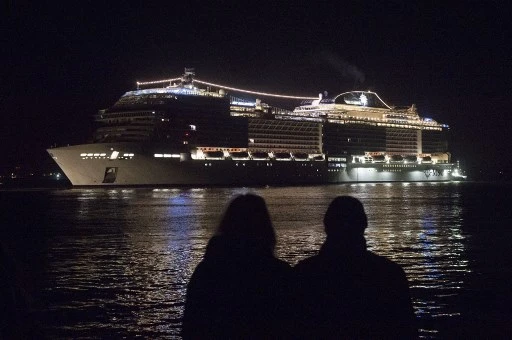 Des passants regardent le navire de croisière MSC Bellissima quittant le chantier naval "Chantiers de l'Atlantique" de Saint-Nazaire le 27 février 2019. Le paquebot "MSC Bellissima", a été construit par les Chantiers de l'Atlantique à Saint-Nazaire. (Sébastien Salom-Gomis / AFP)