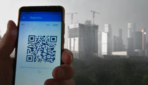 Un homme montre un code QR sur son smartphone à Moscou le 28 juin 2021, au milieu de la crise liée à la pandémie de Covid-19 causée par le nouveau coronavirus. Les citoyens doivent présenter un code QR pour entrer dans les restaurants, certifiant qu'ils sont soit vaccinés, qu'ils ont eu le virus au cours des six derniers mois ou qu'ils ont un test négatif valide. (Alexandre Nemenov/AFP)