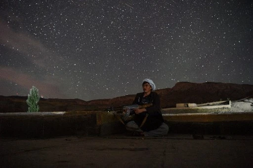 Sur cette photo prise le 15 juillet 2021, un combattant de la milice afghane surveille un avant-poste contre les insurgés talibans dans le district de Charkint dans la province de Balkh. (Farshad Usian/AFP)