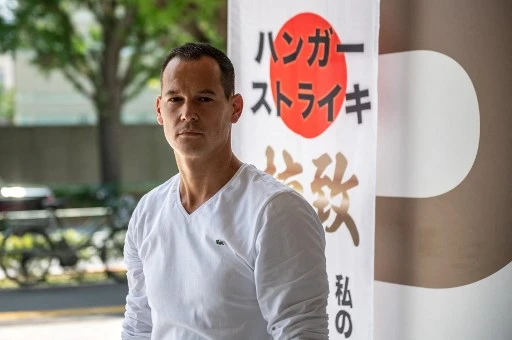 Dans cette photo d'archive prise le 10 juillet 2021, le résident français Vincent Fichot, dont les deux enfants ont été enlevés par leur mère japonaise, pose pour une photo suite à un entretien avec l'AFP au sujet de sa grève de la faim devant une gare. (Philippe Fong/AFP)