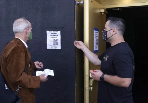 Un portier d'Oasis informe un client qu'une carte de vaccination est requise pour entrer dans le club le 29 juillet 2021 à San Francisco, Californie. (Justin Sullivan/Getty Images/AFP)