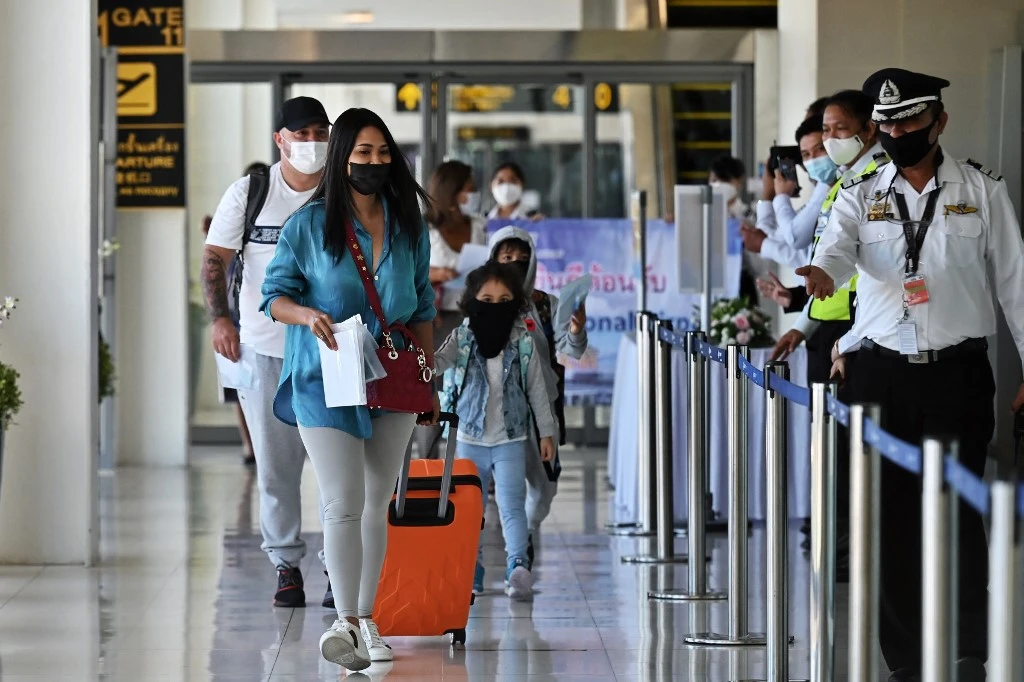 Les passagers d'un vol Etihad Airways en provenance d'Abou Dhabi arrivent à l'aéroport international de Phuket alors que le programme touristique«Phuket Sandbox» a été lancé (AFP)