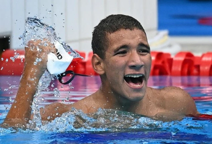 Le Tunisien Ahmed Hafnaoui exulte après sa victoire finale du 400 m libre, à Tokyo, le 25 juillet 2021. AFP