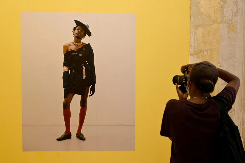 Une femme prend une photo d'une image conceptuelle de Campbell Addy lors de l'exposition «New Black Vanguard» le premier jour du festival de photographie «Les Rencontres d'Arles» dans le sud de la France (AFP)