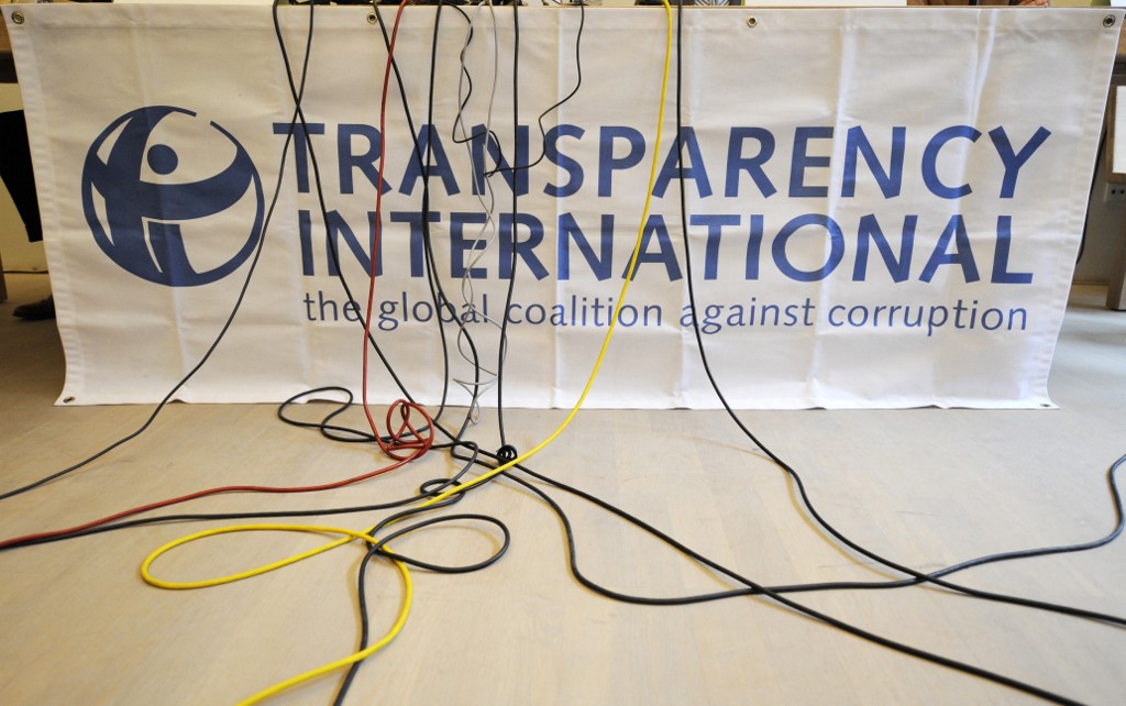 Des câbles de microphone pendent au-dessus d'un logo de Transparency International lors d'une conférence de presse (photo d'archives ) (AFP)