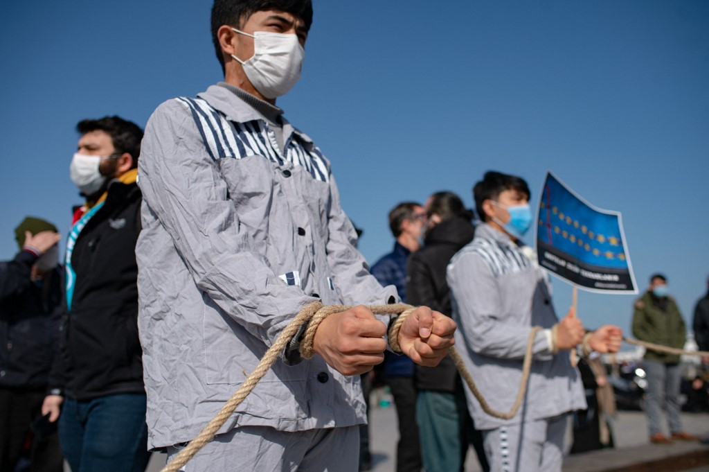 Des membres de la minorité musulmane ouïghoure gardent symboliquement les mains liées avec une corde alors qu'ils manifestent pour demander des nouvelles de leurs proches et exprimer leur inquiétude quant à la ratification d'un traité d'extradition entre la Chine et la Turquie sur la place Uskudar à Istanbul le 26 février 2021 ( AFP)