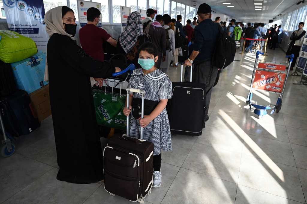 La famille d'un ressortissant afghan travaillant à l'ambassade de France alors qu'elle se prépare à partir sur un vol spécial vers la France, à l'aéroport international Hamid Karzai de Kaboul le 17 juillet 2021. (AFP)