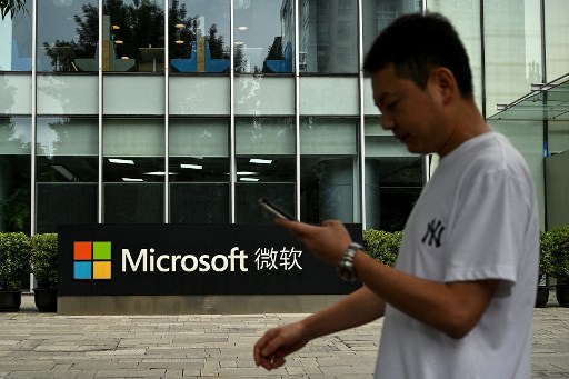 Un homme utilise son téléphone portable alors qu'il marche devant le siège local de Microsoft à Pékin le 20 juillet 2021, le lendemain du jour où les États-Unis ont accusé Pékin d'avoir mené la cyberattaque contre Microsoft et inculpé quatre ressortissants chinois pour le piratage "malveillant" de Mars. (Noël Celis/AFP)