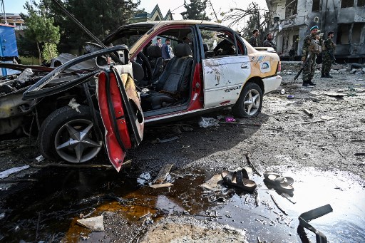 Des agents de sécurité afghans montent la garde près de l'épave d'un véhicule sur le site un jour après l'explosion d'une voiture piégée à Kaboul le 4 août 2021. (Wakil Kohsar / AFP)