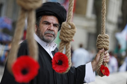 Un manifestant tient un nœud coulant lors d'une manifestation organisée par des partisans du Conseil national de la Résistance iranienne (CNRI) contre l'investiture du nouveau président iranien Ebrahim Raisi devant Downing Street dans le centre de Londres le 5 août 2021. (Adrien Dennis / AFP)