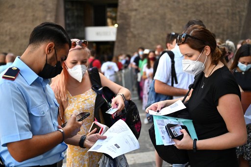 Les visiteurs font scanner leur certificat numérique Covid-19 de l'UE avant d'entrer dans les musées du Vatican, le 6 août 2021, en Italie, alors qu’un Green Pass est requis à partir d'aujourd'hui pour entrer dans les cinémas, musées et sites sportifs en salle, ou manger à l'intérieur dans des restaurants. (Andreas Solaro/AFP)