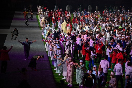 Des artistes dansent alors que les athlètes (à droite) se rassemblent sur le terrain lors de la cérémonie de clôture des Jeux Olympiques de Tokyo 2020, le 8 août 2021 au stade olympique de Tokyo. (Oli Écharpe/AFP)