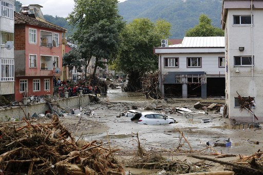 Cette photo publiée par le groupe d'aide humanitaire turc IHH le 12 août 2021 montre une voiture flottant dans l'eau à Kastamonu, après que des crues éclair ont balayé plusieurs régions de la mer Noire au nord de la Turquie. (Document distribué/IHH/AFP)