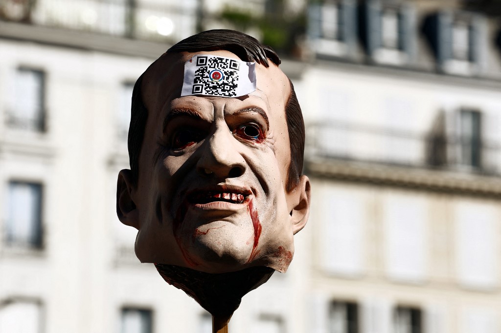 Un masque à l'effigie du président français Emmanuel Macron avec un code QR est affiché lors d'une marche organisée par le parti nationaliste français "Les Patriotes" dans le cadre d'une journée nationale de protestation contre la vaccination Covid-19 obligatoire pour certains travailleurs. (Sameer Al-DOUMY / AFP)