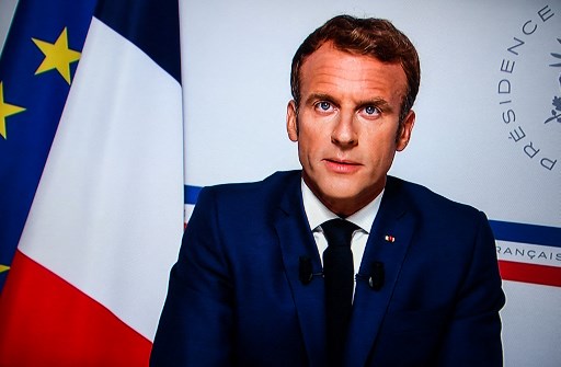 Une image prise à Paris sur un écran de télévision montre le président français Emmanuel Macron s'exprimant sur la situation en Afghanistan, depuis la résidence d'été présidentielle du Fort de Brégançon à Bormes-les-Mimosas, dans le sud-est de la France, le 16 août 2021.(Christophe Archambault /AFP)