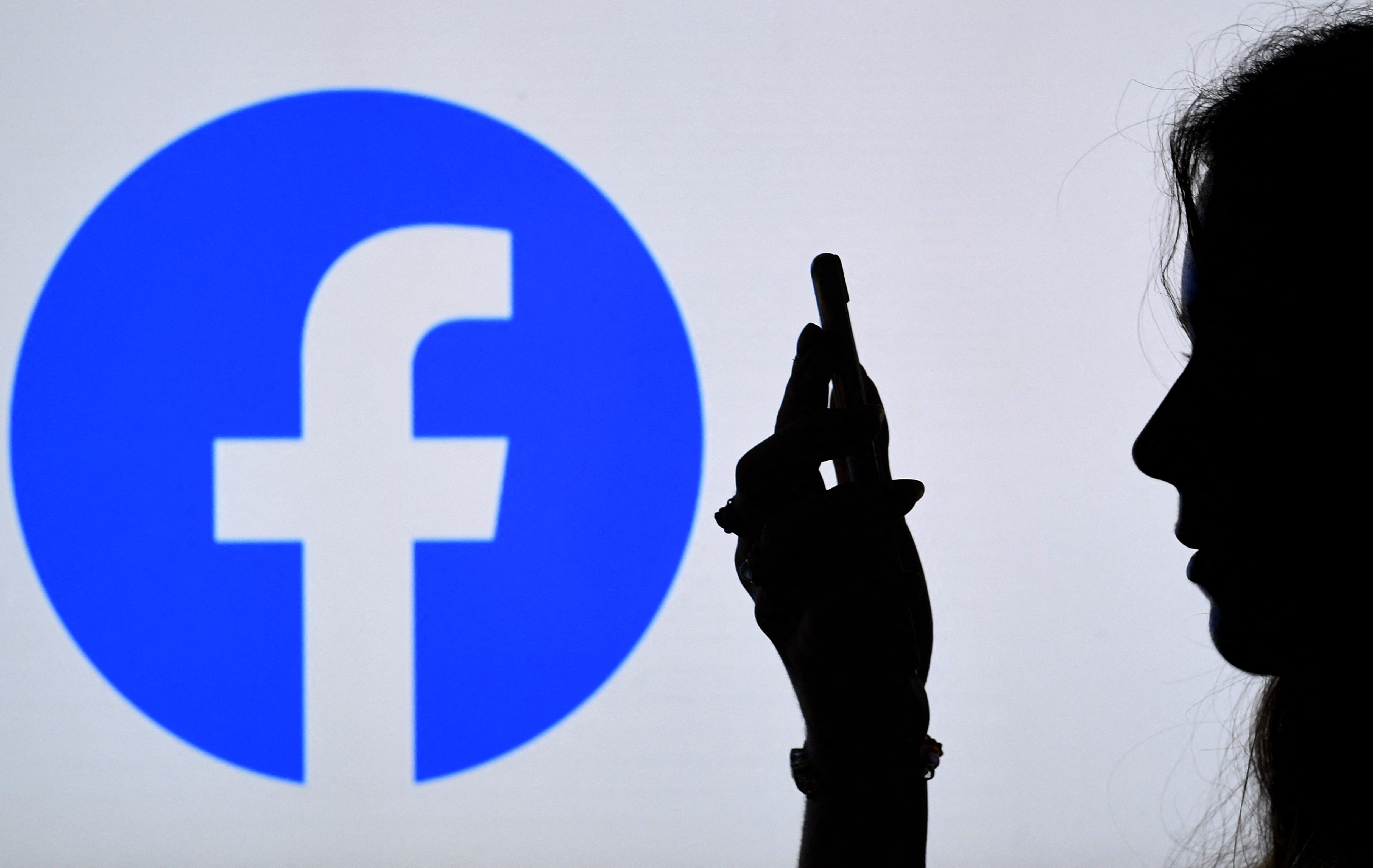 Usager et logo Facebook (AFP)