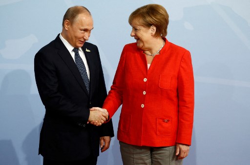 Dans cette photo d'archive prise le 7 juillet 2017, la chancelière allemande Angela Merkel accueille le président russe Vladimir Poutine alors qu'il arrive pour assister au sommet du G20 à Hambourg. (Odd Andersen/AFP)