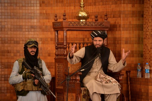 Un imam s'exprime à côté d'un combattant taliban armé lors de la prière du vendredi à la mosquée Abdul Rahman de Kaboul le 20 août 2021, à la suite de la prise de contrôle de l'Afghanistan par les talibans. (Hoshang Hashimi/AFP)