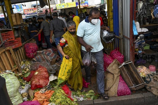 Les gens quittent un marché après avoir acheté des légumes à Colombo le 20 août 2021, au milieu des craintes d'un verrouillage de 10 jours pour freiner la propagation du coronavirus Covid-19. (Ishara S.Kodikara / AFP)