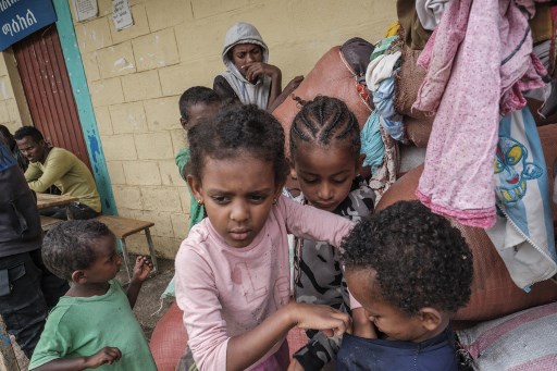Des enfants déplacés par les combats dans le nord de l'Éthiopie jouent parmi des sacs de vêtements à l'école Addis Fana où ils sont temporairement hébergés, dans la ville de Dessie, en Éthiopie, le 23 août 2021. Eduardo Soteras/AFP)
