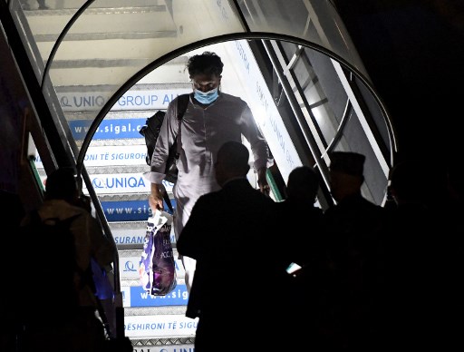 Un Afghan sort d’un vol d'évacuation à l'aéroport Rinas de Tirana le 27 août 2021. L'Albanie a proposé d'accueillir temporairement des milliers de réfugiés afghans évacués de Kaboul par les forces américaines jusqu'à ce que leurs demandes d'asile soient traitées. Les réfugiés seront installés dans des hôtels et des dortoirs d'étudiants préparés à la hâte pour les accueillir. (Gent Shkullaku / AFP)