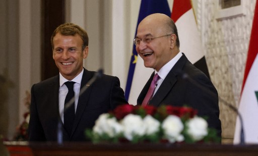 Le président irakien Barham Saleh (à droite) partage un moment léger avec son homologue français Emmanuel Macron lors de leur conférence de presse conjointe après leur rencontre le 28 août 2021 à Bagdad. (Ludovic Marin / Pool/ AFP)