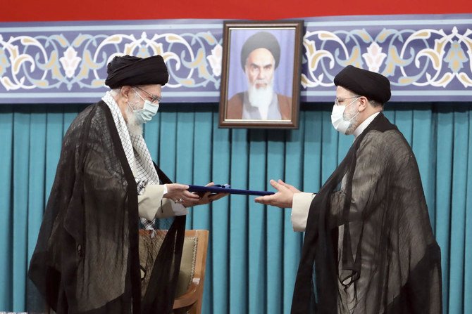 Le guide suprême, l'ayatollah Ali Khamenei, à gauche, donne son sceau officiel d'approbation au président nouvellement élu Ebrahim Raisi lors d'une cérémonie d'approbation à Téhéran le mardi 3 août 2021. (Bureau du guide suprême iranien via AP)