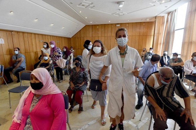 Des Tunisiens attendant leur tour pour se faire vacciner au stade El-Menzah transformé en centre de vaccination, à Tunis. (Fichier/AFP)