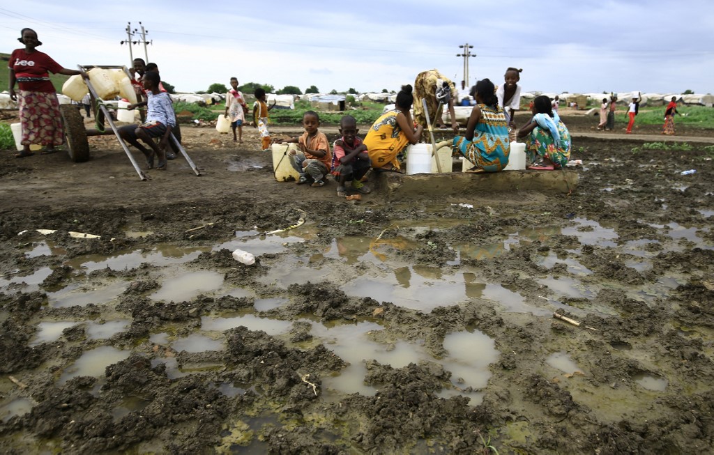 Des réfugiés éthiopiens qui ont fui les combats dans la région du Tigré transportent des jerrycans d'eau dans le camp d'Umm Rakuba, dans l'État de Gedaref (est du Soudan), le 11 août 2021.