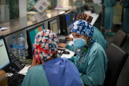Des infirmières discutent d'un patient Covid-19 à l'unité de soins intensifs (USI) de l'hôpital del Mar à Barcelone le 4 août 2021. La Catalogne a le taux d'incidence de Covid-19 le plus élevé d'Espagne. (Josep Lago/AFP)