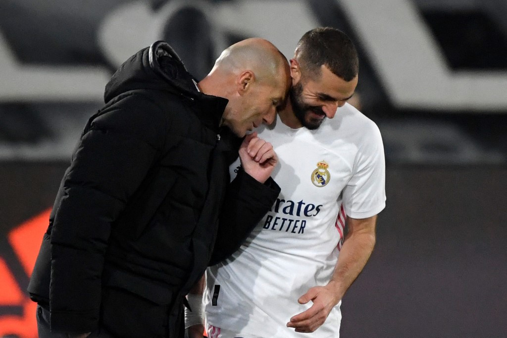 L'attaquant français du Real Madrid Karim Benzema (D) avec l'entraîneur français du Real Madrid Zinedine Zidane après avoir marqué un but lors du match de football de la ligue espagnole entre le Real Madrid CF et l'Athletic Club Bilbao au stade Alfredo di Stefano à Madrid le 15 décembre 2020. OSCAR DEL POZO / AFP