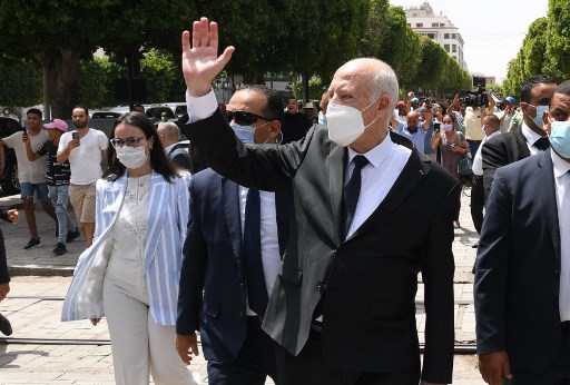 Une photo fournie par la page Facebook officielle de la présidence tunisienne le 1er août 2021 montre le président Kais Saied (au centre) faisant des gestes alors qu'il marche protégé par la sécurité lors d'une tournée dans l'avenue Habib Bourguiba au centre de la capitale Tunis. (Présidence tunisienne/AFP)