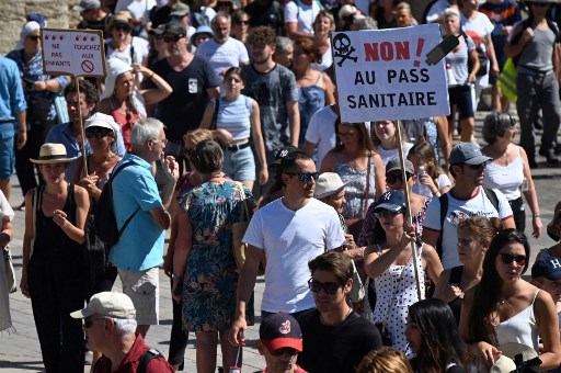 Un manifestant tient une pancarte indiquant «Non au pass sanitaire» lors d'une journée nationale de protestation contre la vaccination obligatoire Covid-19 pour certains travailleurs, et l'utilisation obligatoire du pass sanitaire réclamée par le gouvernement français pour accéder à la plupart des espaces publics, le 28 août 2021.(Sylvain Thomas/AFP)