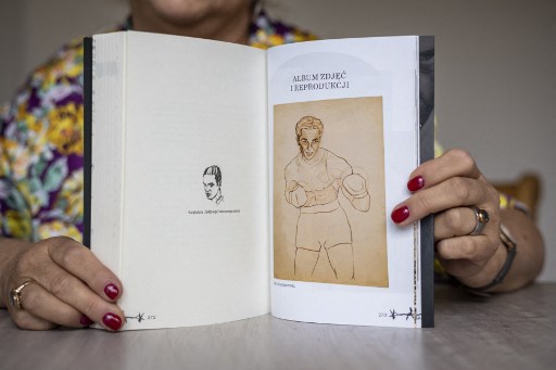 Eleonora Szafran - fille du boxeur d'Auschwitz Tadeusz "Teddy" Pietrzykowski montre son livre sur son père lors d'une interview à Varsovie, le 26 août 2021. (Wojtek Radwanski/AFP)
