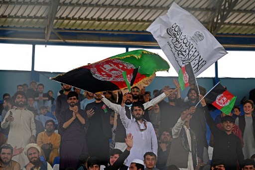 Des spectateurs brandissent des drapeaux afghans et talibans alors qu'ils regardent le match d'essai de cricket Twenty20 entre deux équipes afghanes «Peace Defenders» et «Peace Heroes» au stade international de cricket de Kaboul à Kaboul le 3 septembre 2021. (Aamir Qureshi/AFP)