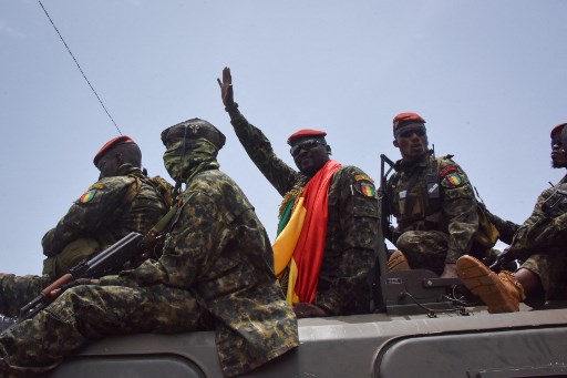 Le lieutenant-colonel Mamady Doumbouya, au centre, chef des forces spéciales de l'armée salue la foule à son arrivée au Palais du Peuple à Conakry le 6 septembre 2021 (Photo, AFP)