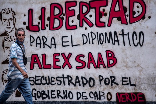 Dans cette photo d'archives prise le 23 février 2021, un homme passe devant un graffiti indiquant "Liberté pour le diplomate Alex Saab, kidnappé par le gouvernement du Cap-Vert" à Caracas. (Youri Cortez/AFP)