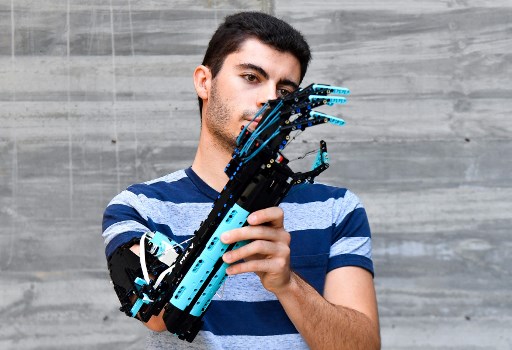Détenteur du record du monde Guinness 2017 et vainqueur du Lego Masters France 2020, l'étudiant universitaire andorran David Aguilar, 22 ans, atteint du syndrome de Poland, pose avec son bras prothétique auto-construit, fabriqué avec des pièces Lego, à Sant Cugat del Valles, près de Barcelone le 9 septembre 2021. (Pau Barrena/ AFP)